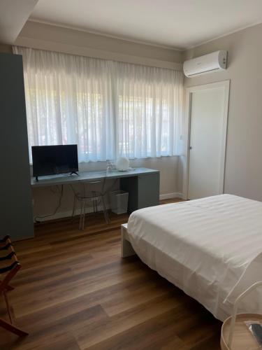 a bedroom with a bed and a desk with a computer at Il Giardinetto - Guest Room Policlinico in Messina