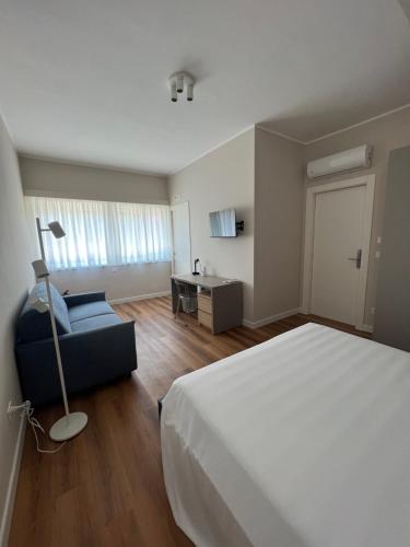 a bedroom with a bed and a chair and a desk at Il Giardinetto - Guest Room Policlinico in Messina