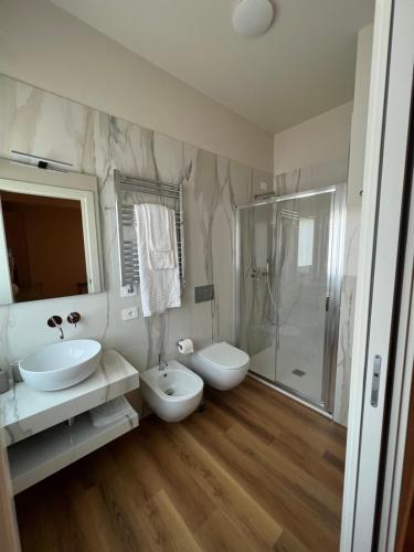 a white bathroom with two sinks and a shower at Il Giardinetto - Guest Room Policlinico in Messina