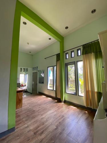バトゥにあるVilla Pring Limaの緑の壁とウッドフロアの空きリビングルーム