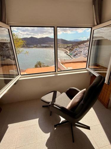 a chair sitting in a room with a large window at 8 Islas in Las Playas