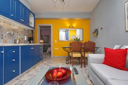 a living room with a couch and a bowl of fruit on a table at Fouxia-Yellow in Skopelos Town