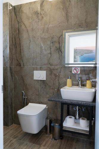 a bathroom with a sink and a tub and a toilet at Hilltop Heaven Hotel in Sarandë