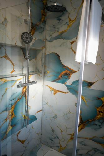 a shower in a bathroom with a marble wall at InterPension in Garbsen