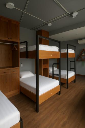 a room with four bunk beds with white sheets at SAPA HUB hostel in Sa Pa