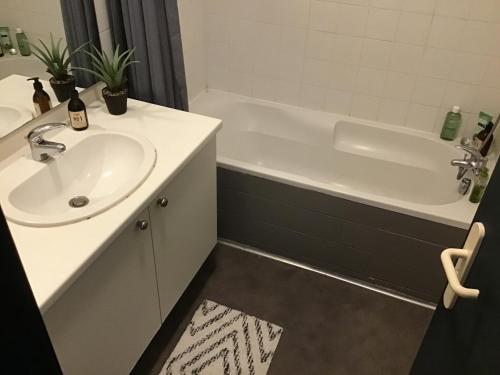 a bathroom with a sink and a bath tub at Chambre Cosy 3 in Montauban