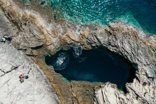 an aerial view of people on the rocks near the ocean at Stone house Casa Lumina in Božava