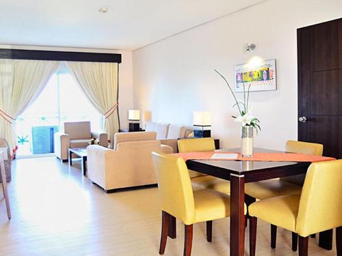 a dining room with a table and yellow chairs at Thunderbird Resorts - Poro Point in San Fernando