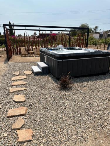 a hot tub and a bench in a yard at Sol del Valle in Valle de Guadalupe