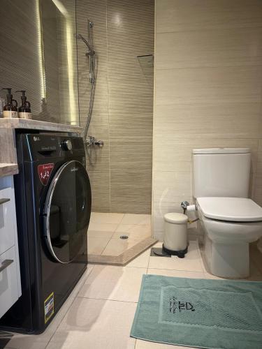 a bathroom with a washing machine and a toilet at G cribs cozy 1bd apartment in El Gouna