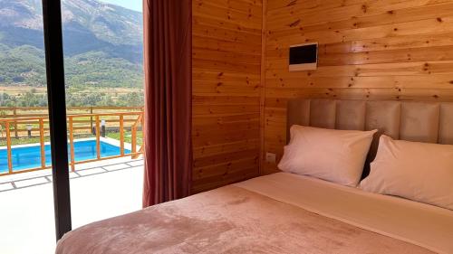 a bedroom with a bed and a view of a mountain at Green Oasis in Fshati i Ri