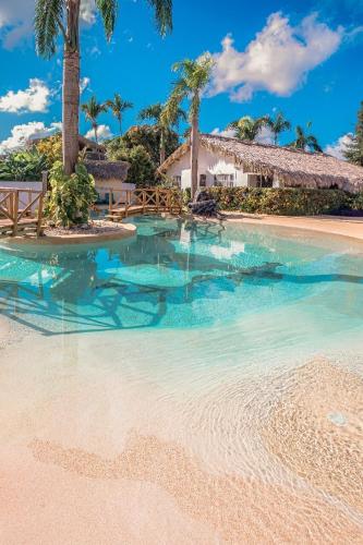 a swimming pool with blue water and palm trees at Guest-Room 1 Palmeras with a pool in Las Galeras in Las Galeras