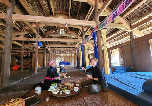 two women sitting around a table with food on it at BanLien Forest Lao Cai in Bắc Hà