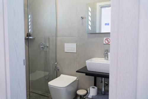 a bathroom with a toilet and a sink and a shower at Hilltop Heaven Hotel in Sarandë