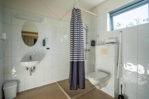 a bathroom with a toilet and a sink at Hótel Skógafoss by EJ Hotels in Skogar
