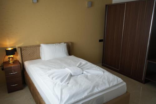 a bedroom with a white bed with a bow on it at InterPension in Garbsen