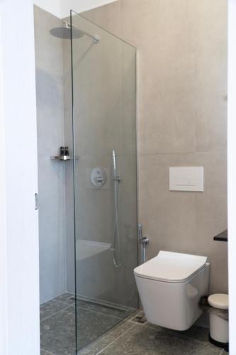 a bathroom with a glass shower with a toilet at Hilltop Heaven Hotel in Sarandë