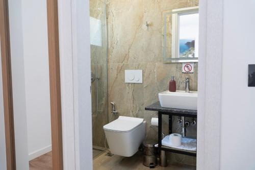 a bathroom with a toilet and a sink at Hilltop Heaven Hotel in Sarandë