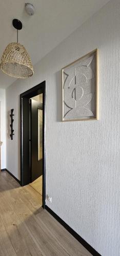 a room with a hallway with a picture on the wall at Elegant & Peaceful - Private Parking in Mulhouse