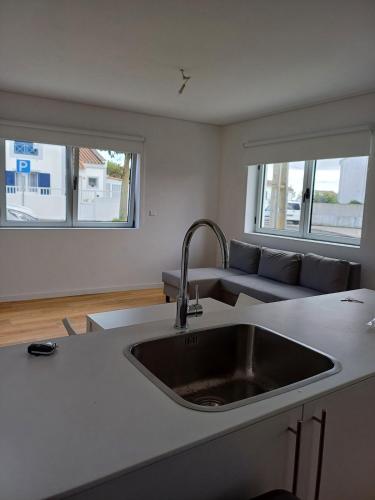 a kitchen with a sink and a living room with a couch at Azure Escape Azores in Arrifes