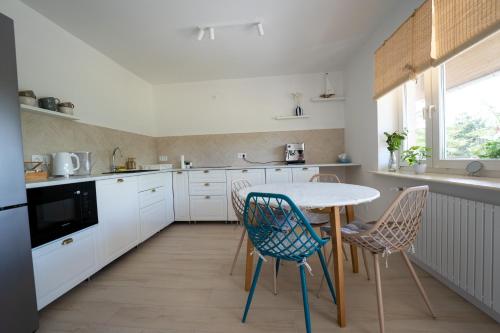 a kitchen with a table and chairs in a kitchen at Apartamenty Wilkasy Jezioro Niegocin in Wilkasy