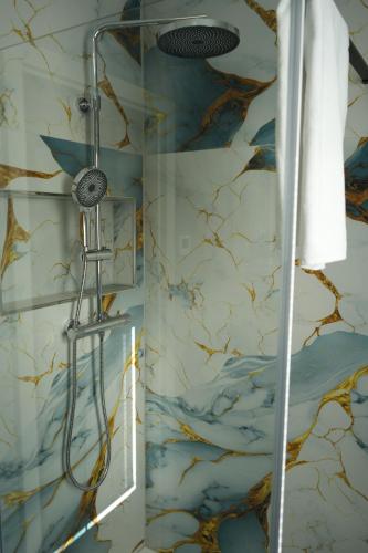 a shower in a bathroom with a marble wall at InterPension in Garbsen