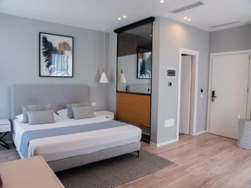 a bedroom with a large bed and a bathroom at Dukes Albania in Vlorë