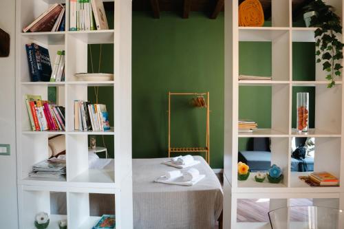 a book shelf with books and a table in a room at L'eco della rosa in Crema