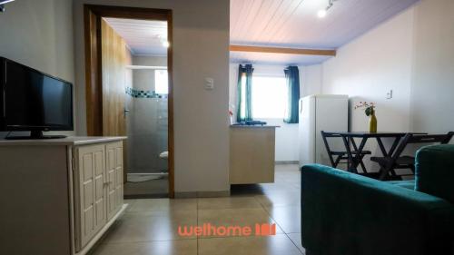 a living room with a television and a dining room at Loft no Centro de Ponta Grossa com Mezanino in Ponta Grossa