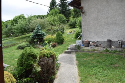a garden with a walkway next to a house at Domček pod Kalváriou in Ružomberok