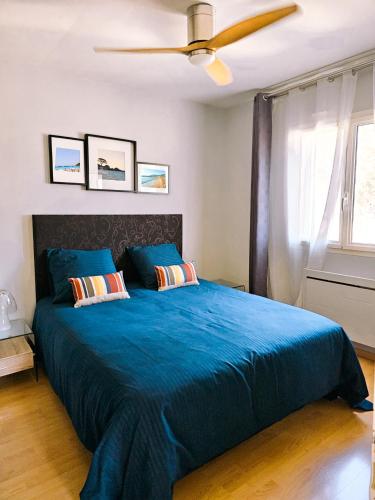 une chambre avec un lit bleu avec un ventilateur de plafond dans l'établissement Villa 6 personnes avec piscine, à Mougins