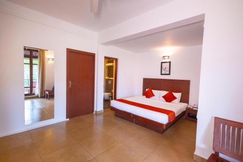 a bedroom with a bed with red pillows at Forest Canopy Thekkady in Thekkady