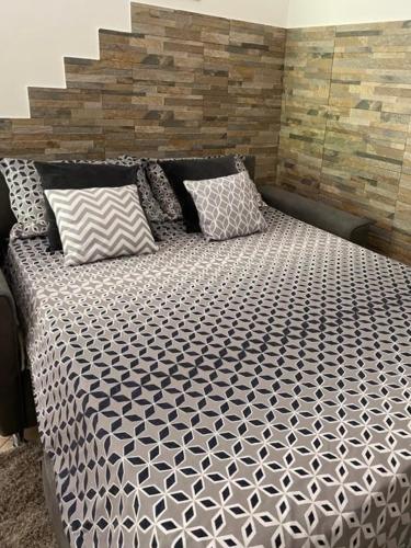 a black and white bed with two pillows on it at Villa Serenice - F2 au calme, climatisé, WIFI et parking gratuit in Nice