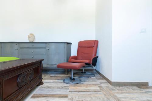 a red chair and a desk in a room at Dimora PietrAnna - Paradiso in Sardegna in Li Valcaggi