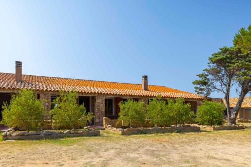 a house with an orange roof and some bushes at Dimora PietrAnna - Paradiso in Sardegna in Li Valcaggi