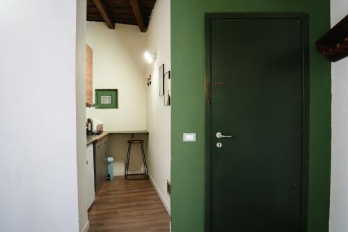 a green door in a hallway with a kitchen at L'eco della rosa in Crema