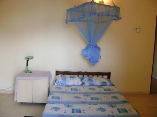 a bedroom with a bed with a blue comforter at Dammika Home in Mount Lavinia
