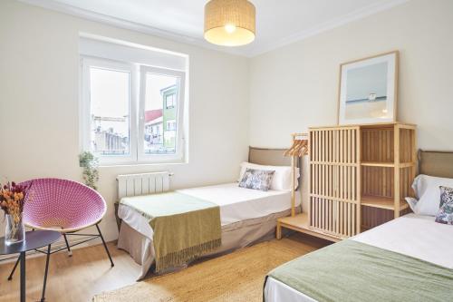 a bedroom with two beds and a table at The Nest - by Wehomes in Santander