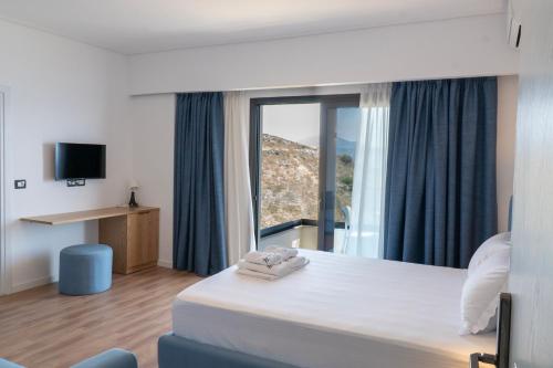 a hotel room with a bed and a large window at Hilltop Heaven Hotel in Sarandë