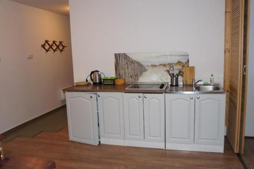 a kitchen with white cabinets and a sink at Willa REIMERS in Krynica Morska