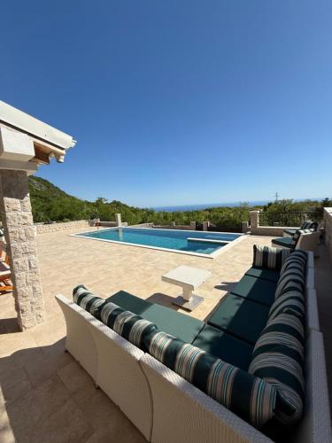 a row of lounge chairs next to a swimming pool at Villa Maluso in Budva