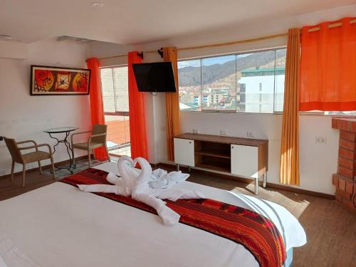 una camera da letto con un letto con sopra degli asciugamani di Hotel Cusco Museo a Cuzco