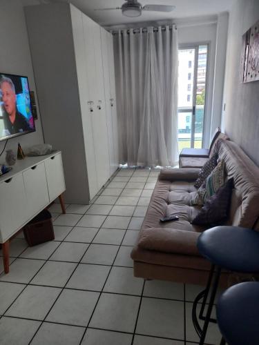 a living room with a couch and a tv at Apart Quartier Latin in Vitória