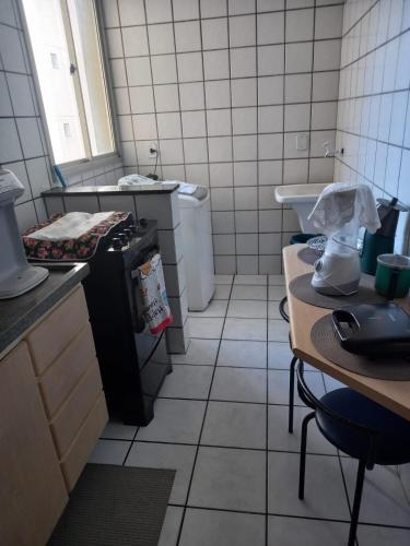 a small kitchen with a sink and a stove at Apart Quartier Latin in Vitória