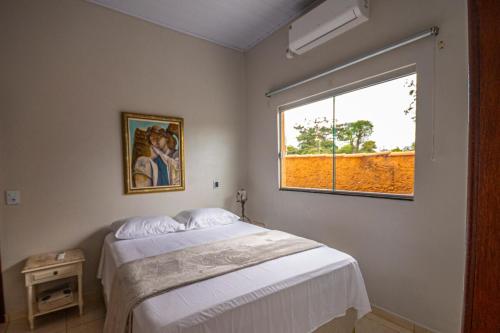 a bedroom with a large bed and a window at Recanto das Araras in Pirenópolis
