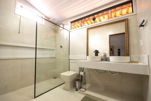 a bathroom with a shower and a toilet and a mirror at Recanto das Araras in Pirenópolis