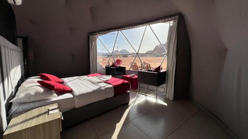 een slaapkamer met een bed en een groot raam bij Wadi Rum Legend Luxury Camp in Wadi Rum