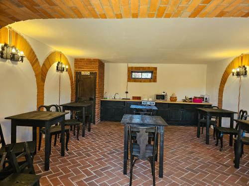 a room with tables and chairs and a kitchen at Curtea Taraneasca in Măldăreşti