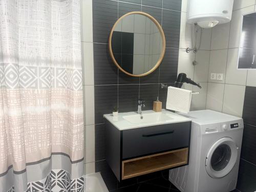 a bathroom with a sink and a washing machine at Apartments Maro in Senj