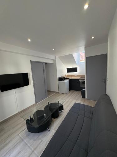 a living room with a couch and a table at Appartement rénové en centre-ville avec terrasse in Millau